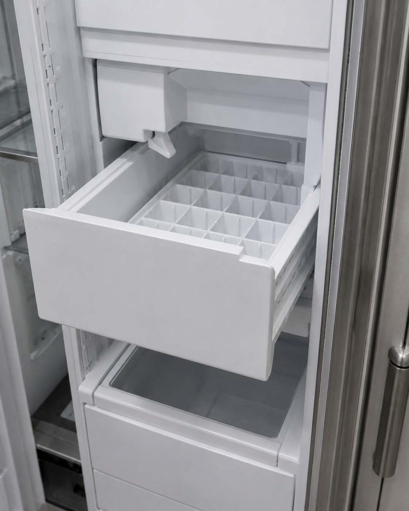 Thermador built-in refrigerator ice maker bin pulled open showing an empty ice tray